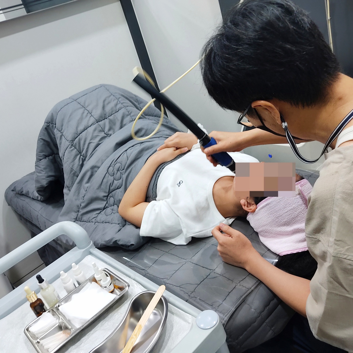 환자가 누운 채 얼굴 부위 시술을 받는 장면