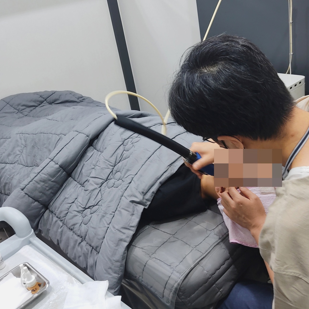 원장이 얼굴 가까이에 기기 핸드피스를 대고 진행하는 시술 장면